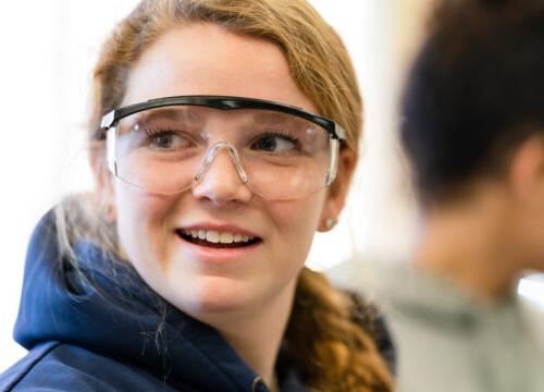 An inspired Trinity college student wearing safety goggles